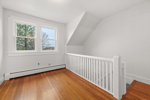 bonus room featuring wood-type flooring, a baseboard radiator, and baseboards