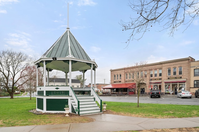 surrounding community featuring uncovered parking and a lawn