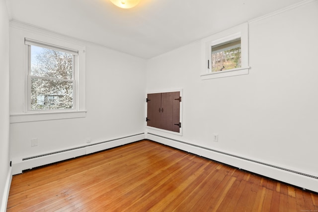 empty room featuring a baseboard radiator and wood-type flooring