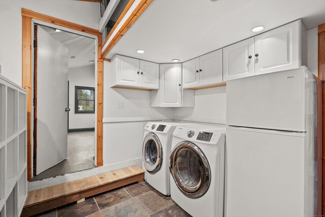 laundry room with recessed lighting, washing machine and clothes dryer, and stone tile flooring