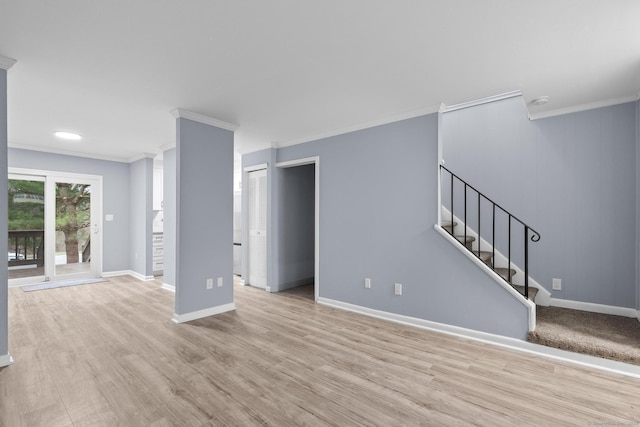 unfurnished living room featuring crown molding, baseboards, stairway, and light wood-type flooring