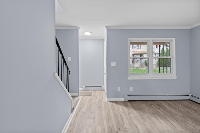 foyer entrance with baseboard heating, crown molding, wood finished floors, and stairs