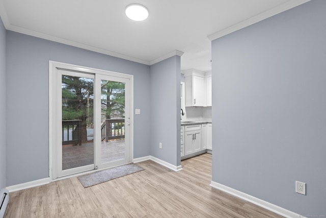 doorway with baseboards, light wood-type flooring, crown molding, a baseboard radiator, and a sink