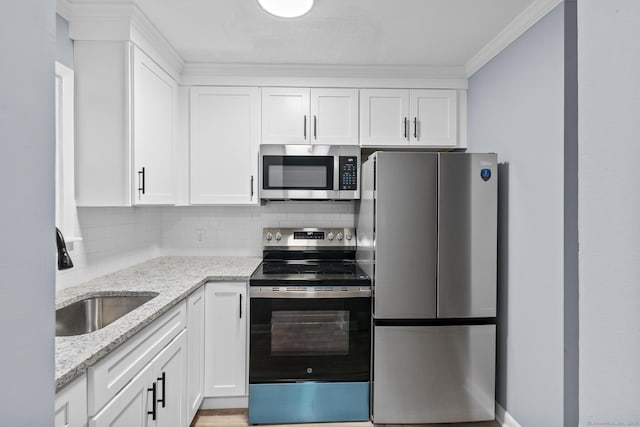 kitchen with appliances with stainless steel finishes, a sink, and white cabinets
