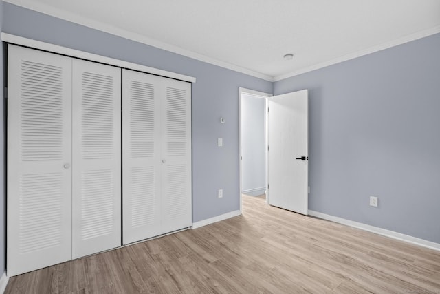 unfurnished bedroom with ornamental molding, baseboards, a closet, and wood finished floors