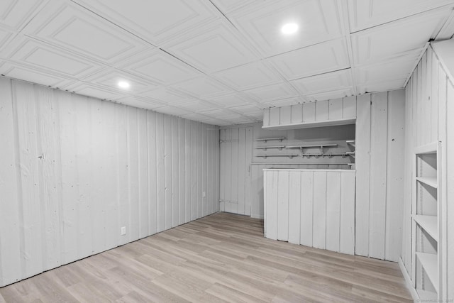 finished basement featuring recessed lighting, wooden walls, and wood finished floors
