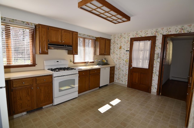kitchen featuring wallpapered walls, under cabinet range hood, a baseboard heating unit, white appliances, and a sink