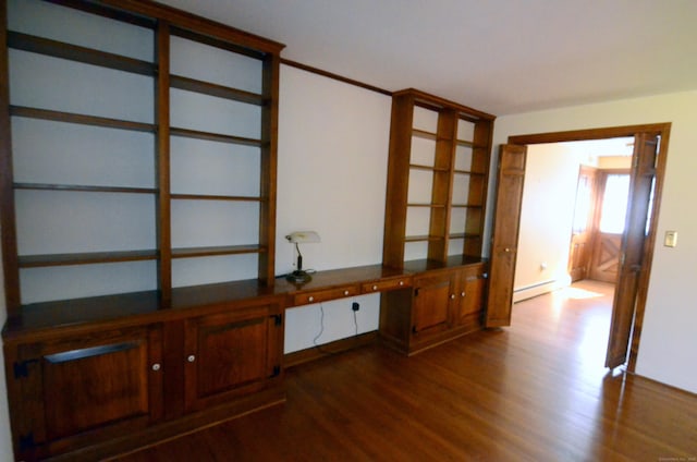 spare room featuring a baseboard radiator, baseboards, and dark wood-style floors