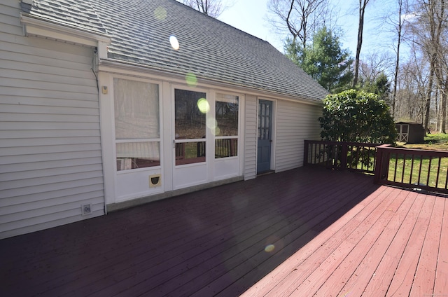 wooden terrace with a storage shed and an outdoor structure