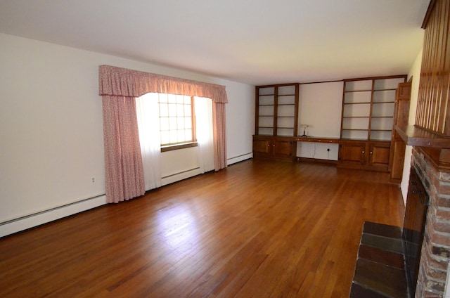 unfurnished living room featuring a fireplace, wood finished floors, and a baseboard heating unit