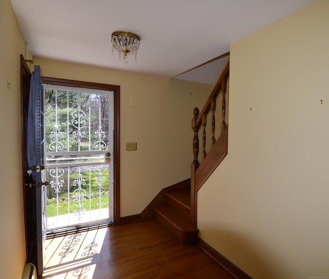 entryway with a wealth of natural light, wood finished floors, baseboards, and stairs