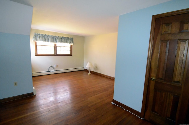 spare room featuring dark wood-style flooring, baseboards, and baseboard heating