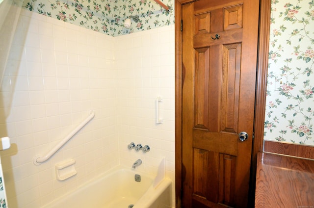 bathroom featuring wallpapered walls and shower / tub combination