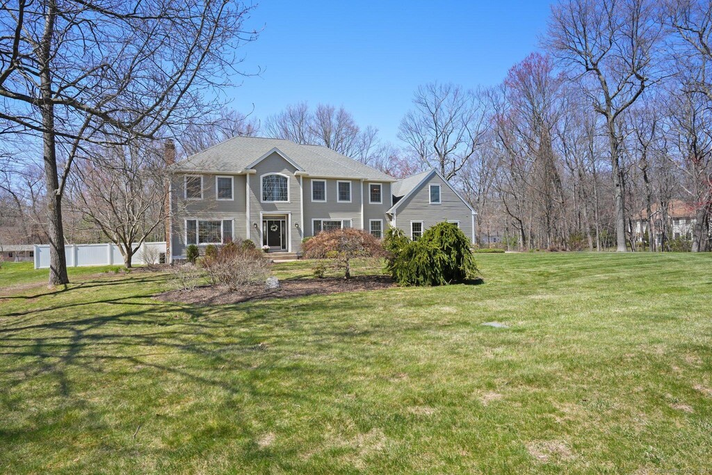 65 Elizabeth Dr, Southington, CT 06489 - view of front of house featuring a chimney, a front lawn, and fence