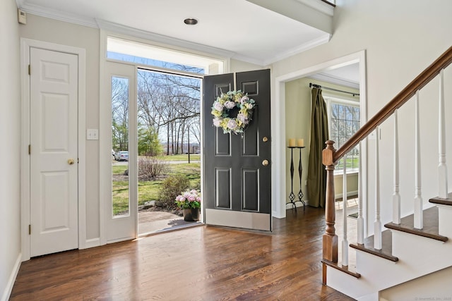 foyer with wood finished floors, stairs, and ornamental molding