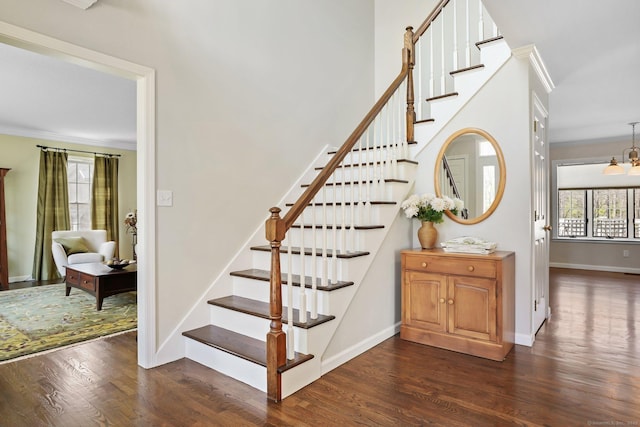staircase featuring baseboards, wood finished floors, and ornamental molding