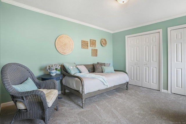 bedroom featuring two closets, carpet flooring, crown molding, and baseboards