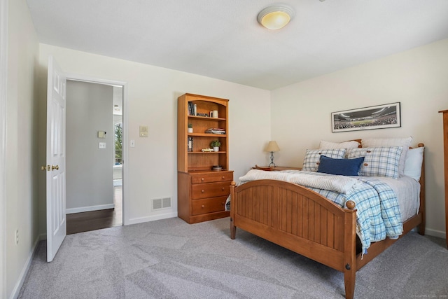 carpeted bedroom featuring baseboards and visible vents