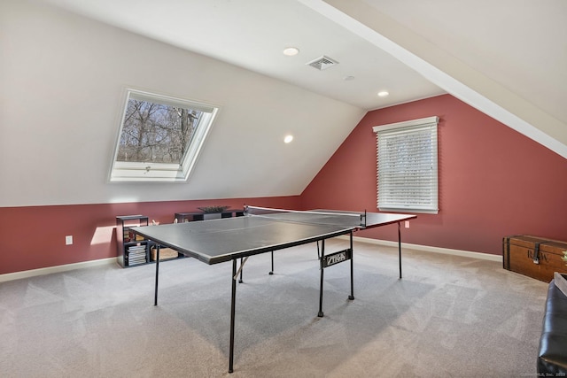 rec room with lofted ceiling with skylight, visible vents, baseboards, and light carpet