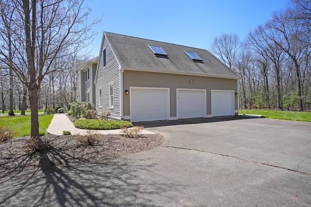 view of property exterior with driveway and roof with shingles
