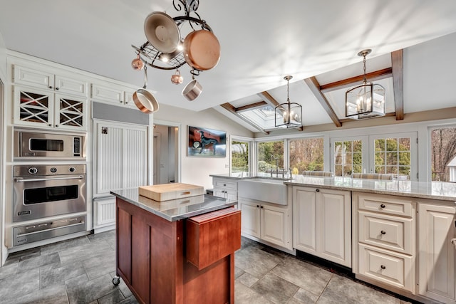 77 Eastfield Rd, Waterbury, CT 06708 - kitchen with an inviting chandelier, a warming drawer, built in appliances, a sink, and lofted ceiling with skylight