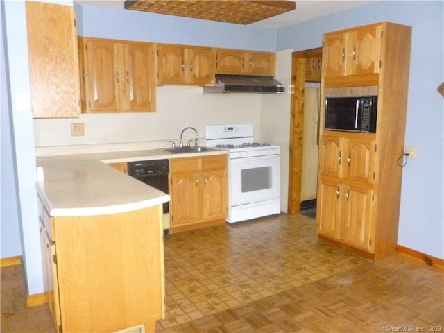 kitchen featuring baseboards, a sink, light countertops, under cabinet range hood, and black appliances
