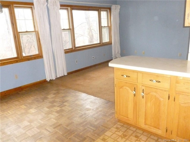 kitchen featuring light countertops, baseboards, and light floors
