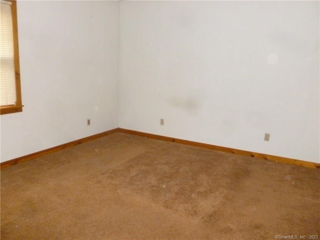 carpeted empty room with baseboards