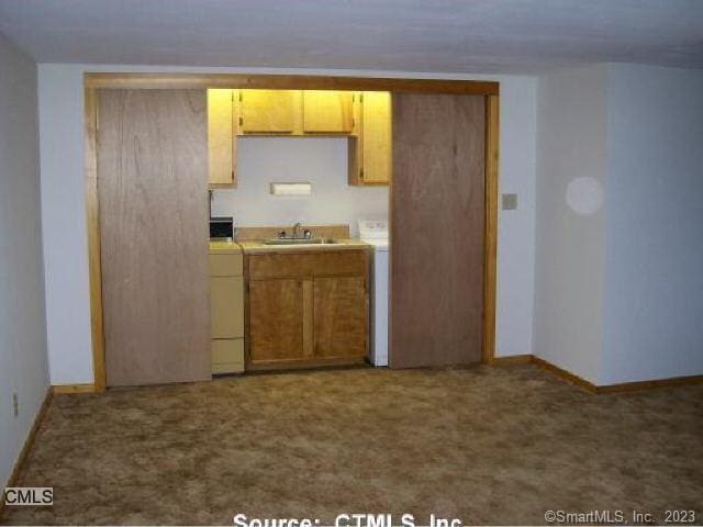 197 Lee Farm Dr, Southbury, CT 06488 - kitchen featuring a sink, carpet, baseboards, and washer / dryer
