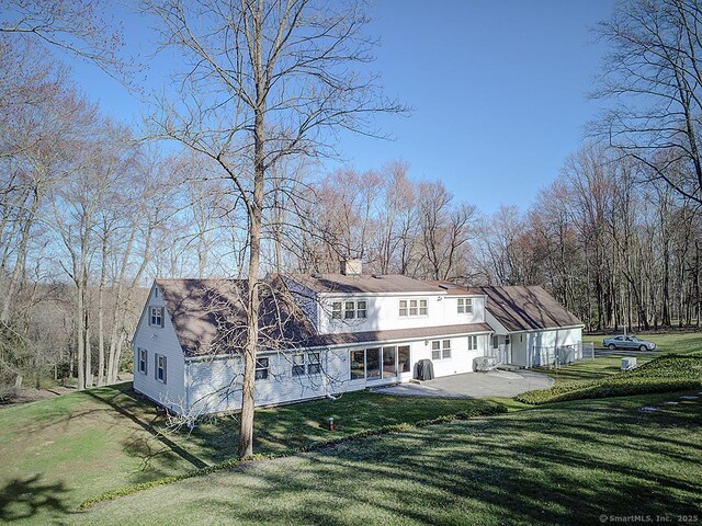 10 Edgehill Dr, Woodbridge, CT 06525 - rear view of house with a lawn, a patio, and a chimney