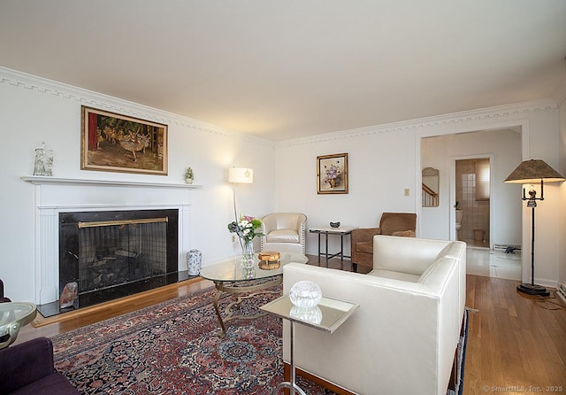 10 Edgehill Dr, Woodbridge, CT 06525 - living room featuring wood finished floors, a fireplace with raised hearth, crown molding, and baseboards
