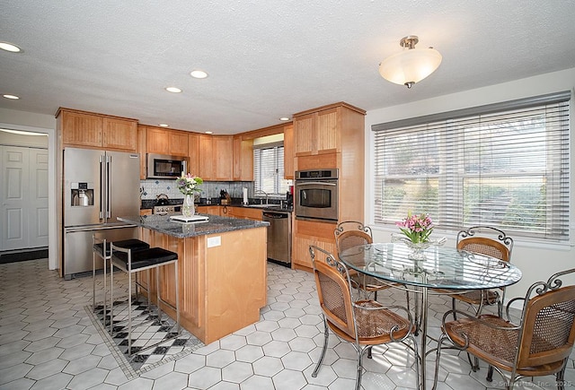 10 Edgehill Dr, Woodbridge, CT 06525 - kitchen with appliances with stainless steel finishes, recessed lighting, a center island, a breakfast bar area, and tasteful backsplash
