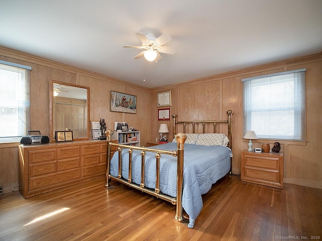 10 Edgehill Dr, Woodbridge, CT 06525 - bedroom with light wood finished floors, multiple windows, a ceiling fan, and wood walls