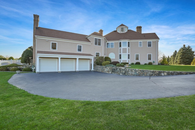 7 Long Meadow Ln, Redding, CT 06896 - view of front of home featuring a chimney, an attached garage, driveway, and a front yard