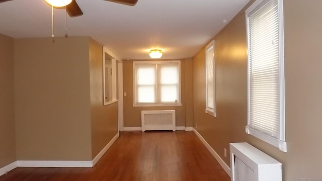 doorway to outside featuring baseboards, wood finished floors, ceiling fan, and radiator