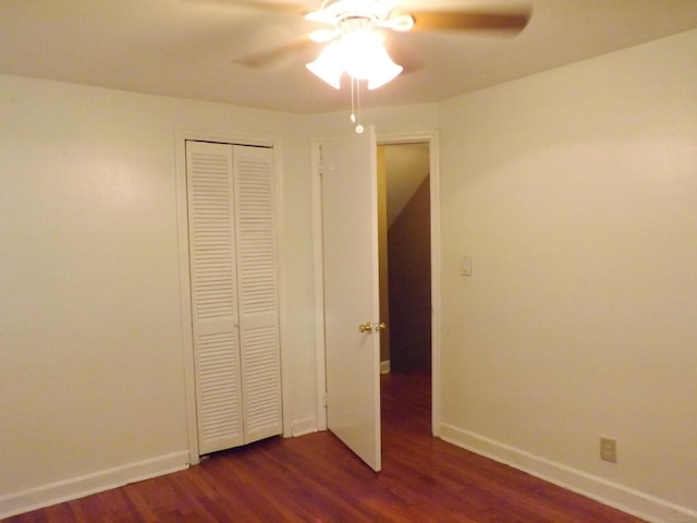 unfurnished bedroom featuring baseboards, a closet, ceiling fan, and dark wood finished floors