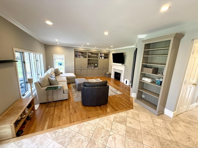 living area with crown molding, built in features, a fireplace, baseboards, and recessed lighting