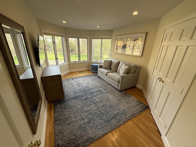 living room featuring baseboards, wood finished floors, and recessed lighting