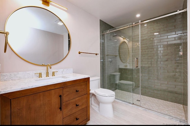 full bathroom with toilet, a shower stall, and vanity