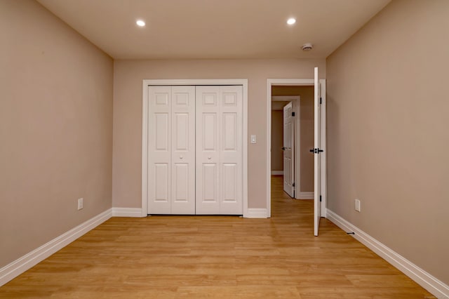 unfurnished bedroom with recessed lighting, baseboards, light wood-style flooring, and a closet