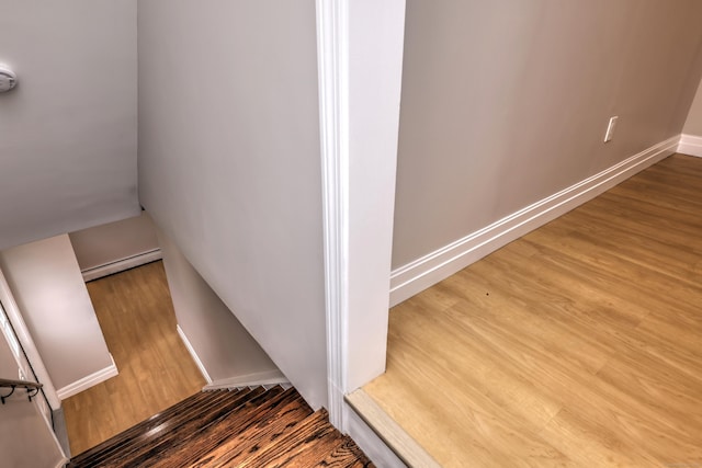 staircase with wood finished floors and baseboards