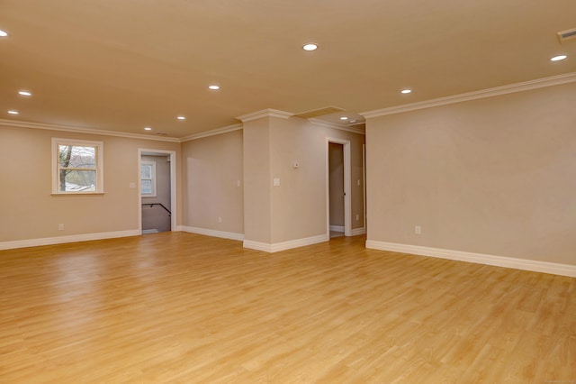 spare room featuring light wood-type flooring, crown molding, recessed lighting, baseboards, and attic access