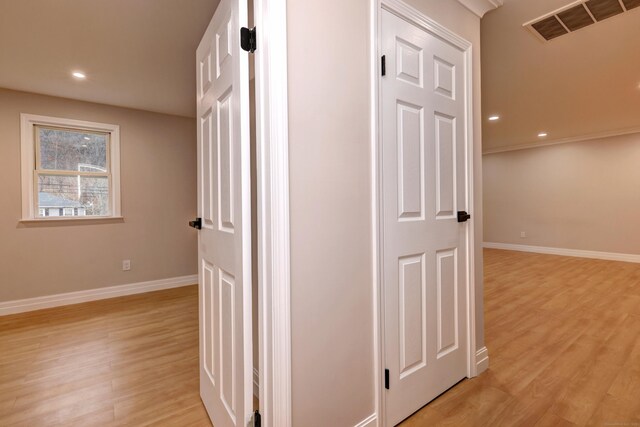 corridor featuring light wood-style flooring, baseboards, and recessed lighting