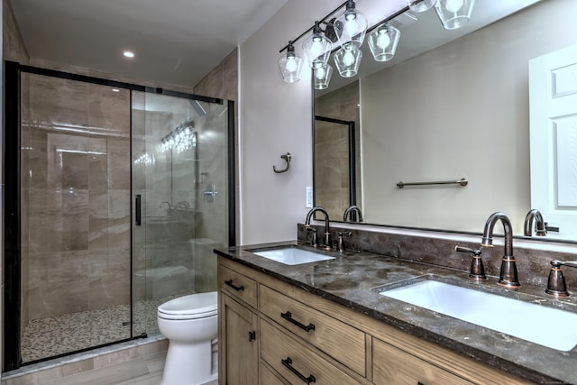 full bath featuring a shower stall, toilet, and double vanity