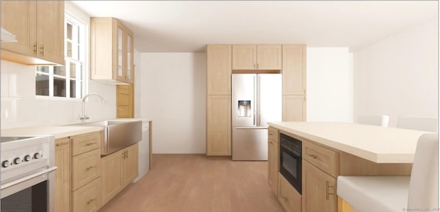 kitchen with fridge with ice dispenser, light brown cabinetry, range, black oven, and a sink