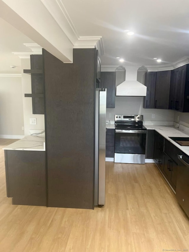 kitchen featuring appliances with stainless steel finishes, wall chimney exhaust hood, crown molding, light wood-style floors, and dark cabinets