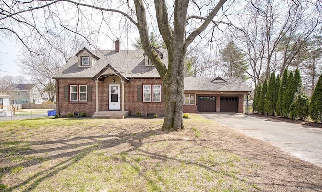 view of front facade with a garage, fence, a chimney, brick siding, and driveway