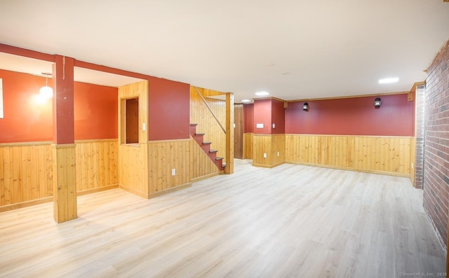 finished basement with wooden walls, wainscoting, and wood finished floors