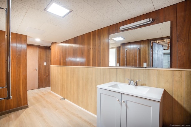interior space with wood walls, wood finished floors, and vanity