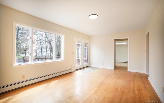 unfurnished room with light wood-style floors, a baseboard radiator, baseboards, and french doors